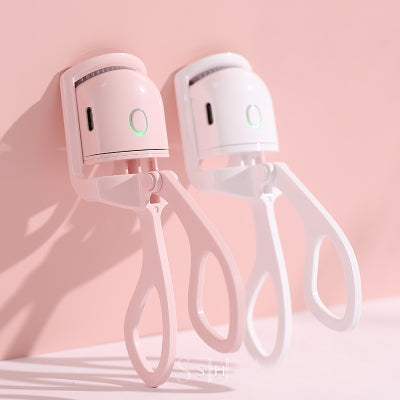 Electric lash curler in use — heated comb lifting and curling natural lashes