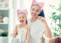 Spa headband worn during skincare routine — soft elastic bow keeps hair back